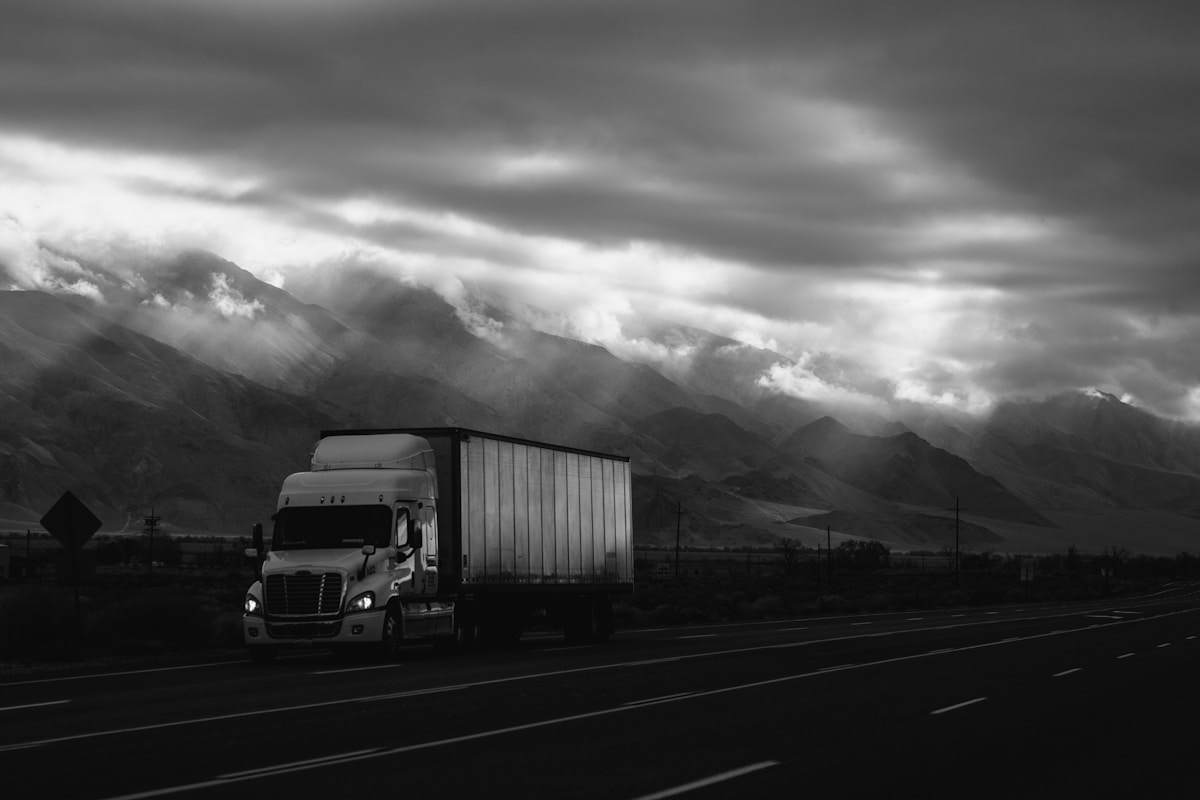Tractor-trailer on the highway under a dramatic sky